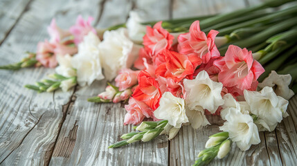 Freshly cut gladiolus flowers in white, pink, and red hues with green stems, elegantly laid on rustic wooden planks, evoking a natural and vintage charm.