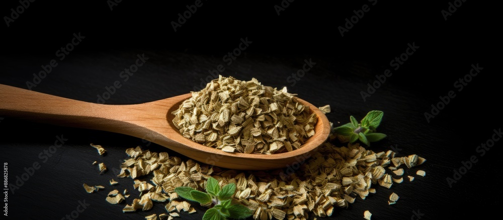 Poster a top-down view of dried oregano herbs in a wooden spoon against a black background with a close-up 