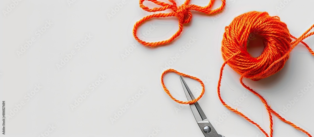 Poster A color string pattern on a white backdrop features an orange thread with a knot, scissors nearby, presented as a composition with copy space image.