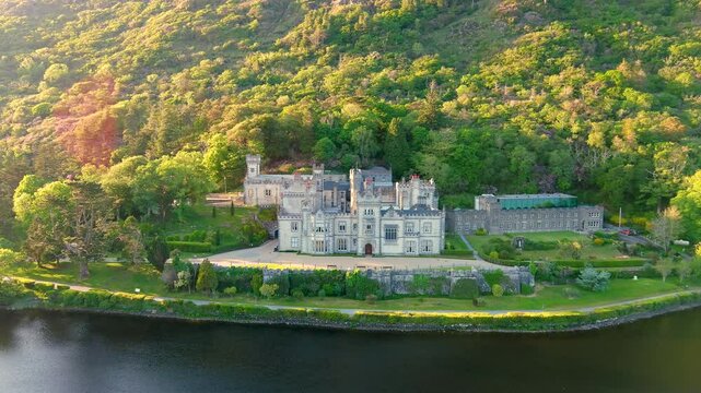 Kylemore Abbey at sunset. A Benedictine monastery founded on the grounds of Kylemore Castle. Connemara sunny summer evening aerial landscape. Famous tourist attraction in County Galway, Ireland.