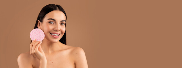 Face cleansing concept. Headshot of happy attractive brunette long-haired naked young woman showing...