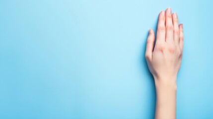  A person's hands against a blue backdrop, one hand reaching towards the camera