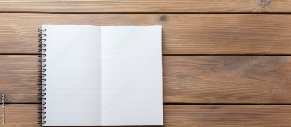 Sticker notebook and pen on a wooden table with available space for text or education message in the image.