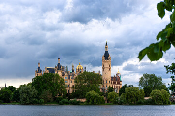Fototapeta premium Schwerin Castle at sunset and dramatic clouds. Castle island just before the rain. 
