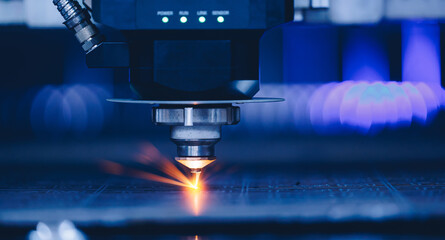 Closeup CNC gas cutting metal sheet, sparks fly. Blue steel color, modern industrial technology.