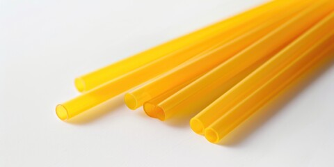 A bunch of yellow straws sit on top of a table, perfect for use in event planning, party decorations, or as a prop for photography