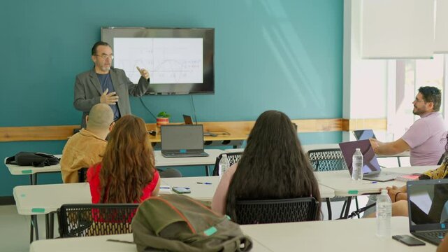 Group of college students paying attention to their professor while he is giving the class.