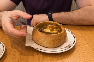 Adult person enjoying authentic French onion soup in cafe