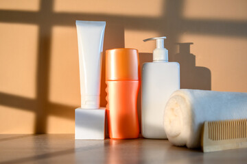 White plastic container with dispenser, orange container, white towel.