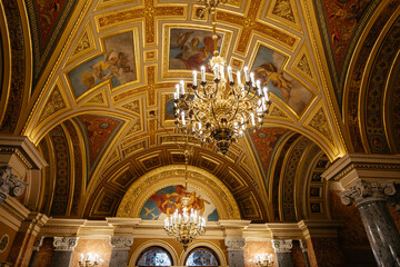 Fototapeta premium Budapest, Hungary May, 18 2024. A symmetrical, circular pattern of wide angle view on a ceiling of Opera house in Hungary. Interior details of the Hungarian State Opera in Budapest
