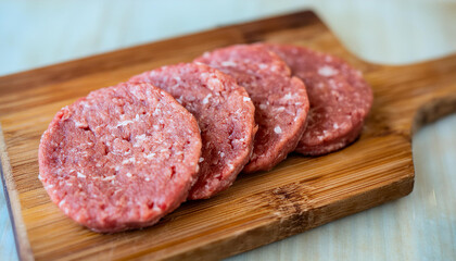Raw veal cutlets on chopping board, before cooking for hamburgers and other dishes. Tasty food.