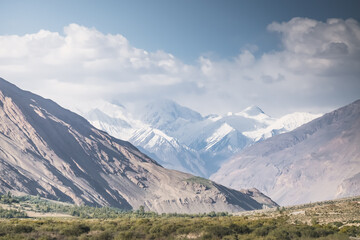 Panorama of Tien Shan mountain range with snow and glaciers, and rocky peaks in Tajikistan in Pamir, mountain range for background in evening