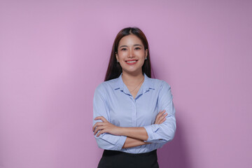 Young businesswoman is smiling with her arms crossed, showing confidence and a positive attitude in...