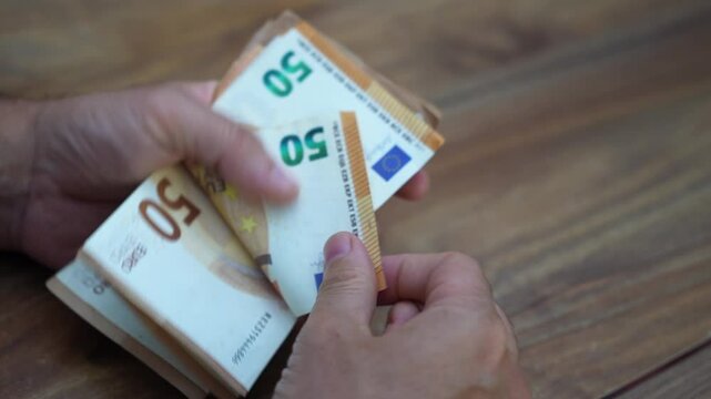 International consultant counts euro banknotes from consulting fees providing strategic advice and insights to multinational corporations navigating European markets