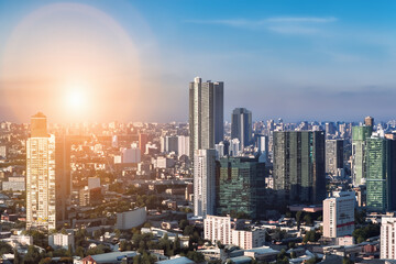 Fototapeta premium Rays of sun over megapolis on a foggy morning. urban sky sunrise concept. city illuminated by sun in the early morning. a city illuminated by the rays of the sun lifestyle in the early morning.