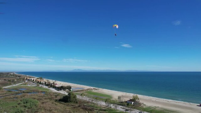Powered paragliding in Greece near Meteora on the coast line over beautiful sandy beaches, paramotor flying in a see breeze,aerial panorama landscape view of Greek nature,outdoor concept