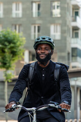 black African businessman commutes to work on e-bike in city bike lane