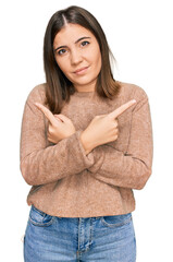 Young beautiful woman wearing casual clothes pointing to both sides with fingers, different direction disagree