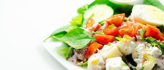 A plate of food with a salad, eggs, and a sauce