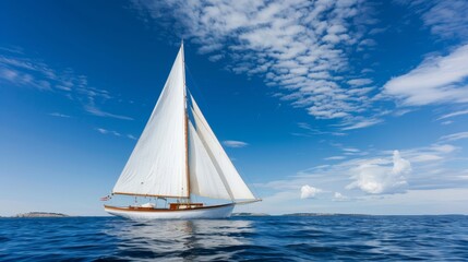  A sailboat in the midst of the ocean beneath a blue sky with wispy clouds