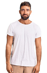 Fototapeta premium Young hispanic man wearing casual white tshirt depressed and worry for distress, crying angry and afraid. sad expression.