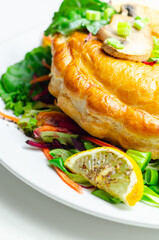 A plate of food with a meat dumpling and a lemon wedge on top