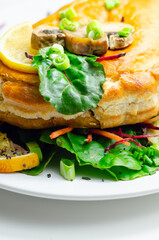 A plate of food with a meat dumpling and a lemon wedge on top