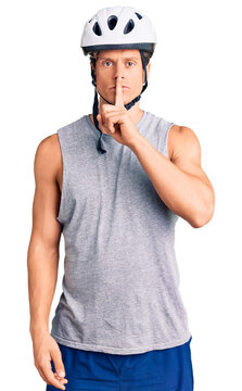 Young handsome man wearing bike helmet asking to be quiet with finger on lips. silence and secret concept.