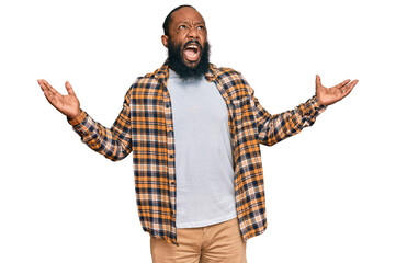 Young african american man wearing casual clothes crazy and mad shouting and yelling with...