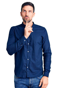 Young handsome man wearing casual shirt thinking concentrated about doubt with finger on chin and looking up wondering