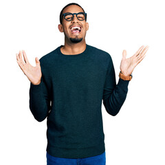 Young african american man wearing casual clothes and glasses celebrating crazy and amazed for...