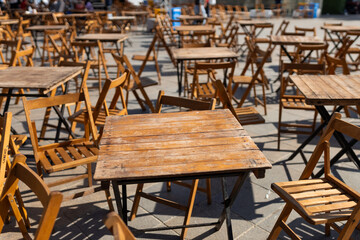 Outdoor street cafe tables ready for service. Empty cafe terrace with table and plastic chair, morning time. Food concept