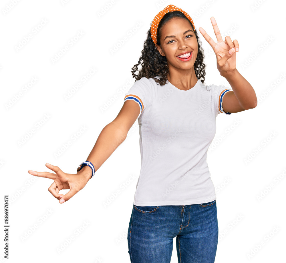 Poster young african american girl wearing casual clothes smiling with tongue out showing fingers of both h