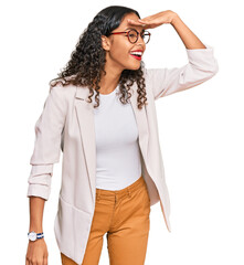 Young african american girl wearing business clothes very happy and smiling looking far away with hand over head. searching concept.