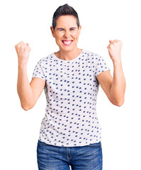 Young woman with short hair wearing casual clothes screaming proud, celebrating victory and success very excited with raised arms