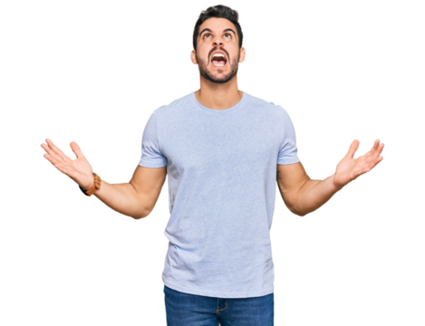 Young hispanic man wearing casual clothes crazy and mad shouting and yelling with aggressive expression and arms raised. frustration concept.