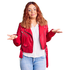 Young latin woman wearing red leather jacket clueless and confused expression with arms and hands...