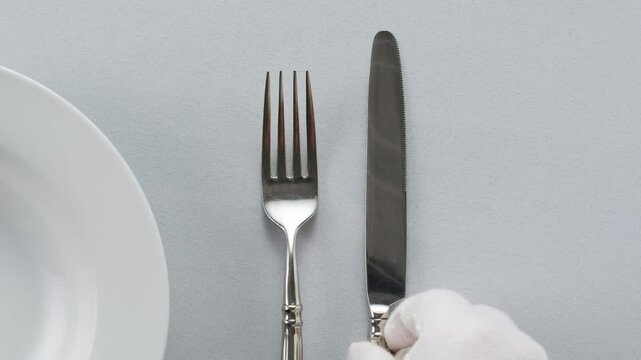 Elegant table setting with white tableware plates, cutlery, and glassware for a classy dining, fancy expensive restaurant dinner