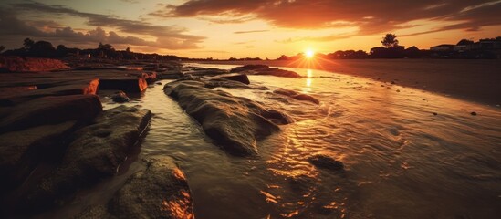 Sunset over a Rocky Beach with a Stream of Water