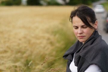 A young smiling beautiful girl with collected hair and a sweater thrown over her shoulders against...