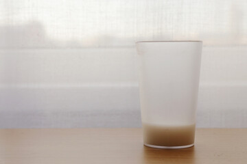 Glass with liquid on the table.