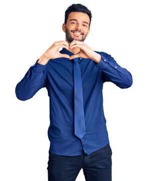 Young handsome hispanic man wearing business clothes smiling in love showing heart symbol and shape with hands. romantic concept.