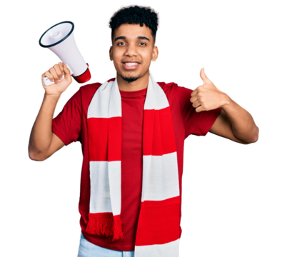 Young african american man football hooligan holding megaphone smiling happy and positive, thumb up doing excellent and approval sign - Powered by Adobe
