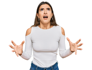 Young hispanic woman wearing casual clothes crazy and mad shouting and yelling with aggressive expression and arms raised. frustration concept.