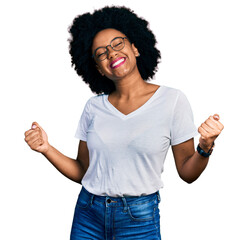 Young african american woman wearing casual white t shirt very happy and excited doing winner...
