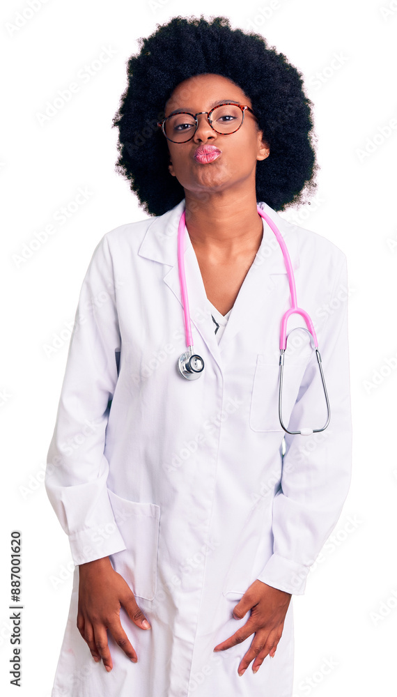 Sticker Young african american woman wearing doctor coat and stethoscope looking at the camera blowing a kiss on air being lovely and sexy. love expression.