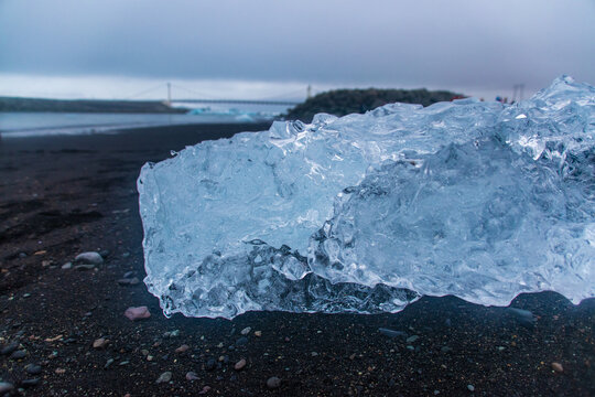 stranded icebergs on a dark pebbly beach in j&ouml;kuls&aacute;rl&oacute;n in iceland