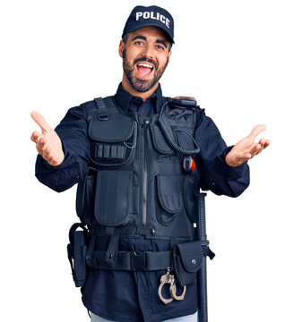 Young hispanic man wearing police uniform smiling cheerful offering hands giving assistance and acceptance.