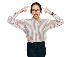 Young hispanic girl wearing casual clothes and glasses smiling pointing to head with both hands finger, great idea or thought, good memory