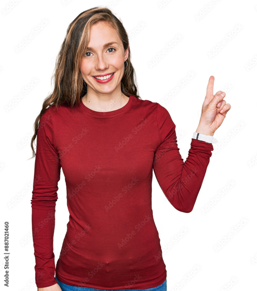 Sticker Young blonde woman wearing casual clothes with a big smile on face, pointing with hand finger to the side looking at the camera.